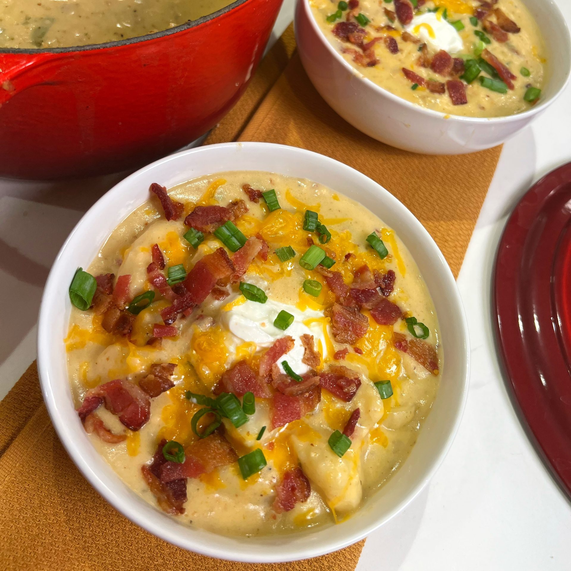 Creamy loaded baked potato soup in a white bowl.