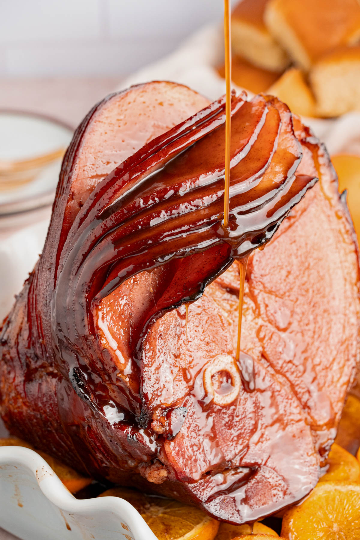 Basting the cooked ham with the remaining glaze.