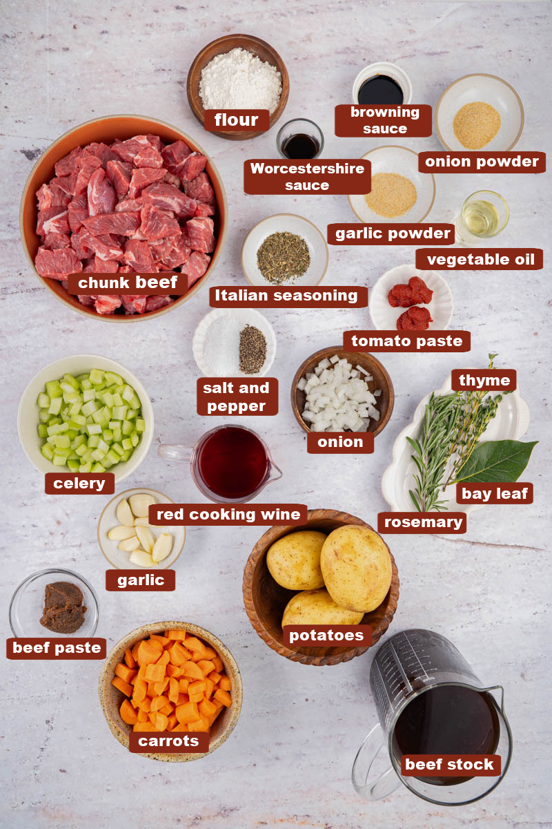 All of the ingredients for stove top beef stew in bowls on a countertop.