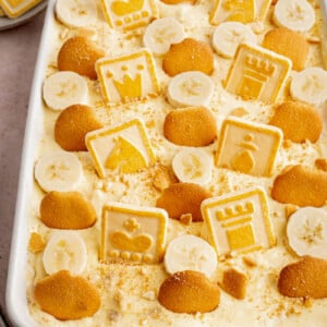Banana pudding in a white baking dish with chessman cookies and vanilla wafers garnished on top.