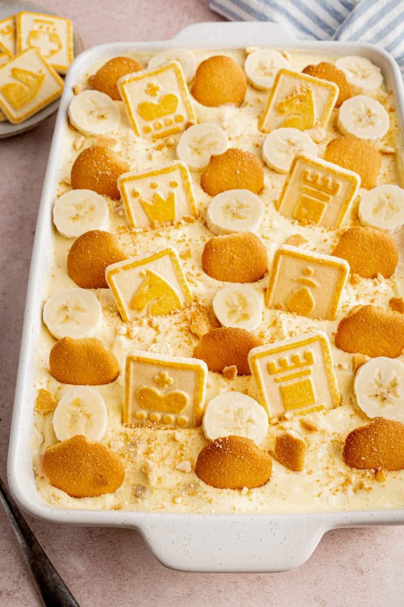 Banana pudding in a white baking dish with chessman cookies and vanilla wafers garnished on top. 