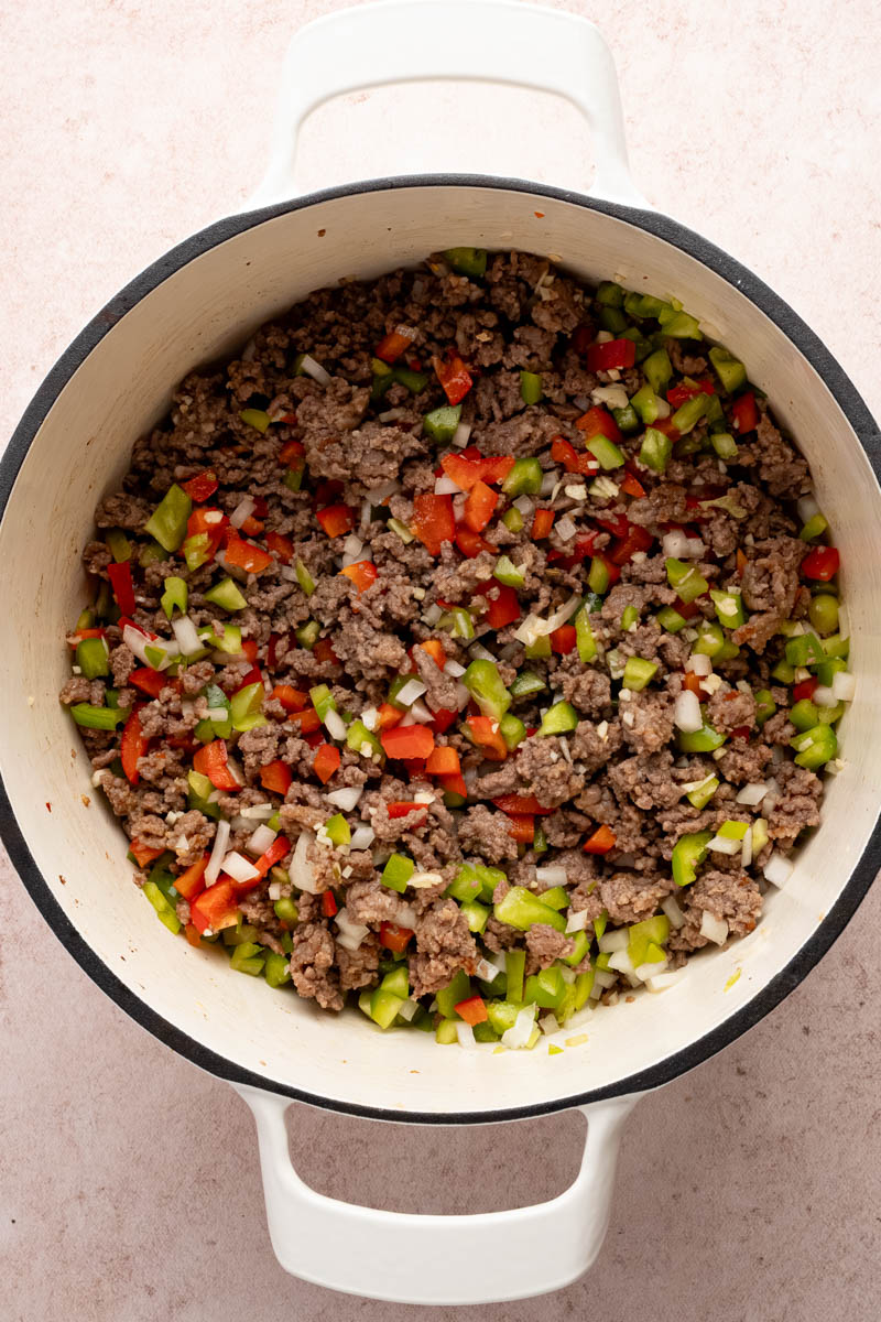 The meat sauteed with bell peppers before adding the sauce and other ingredients.