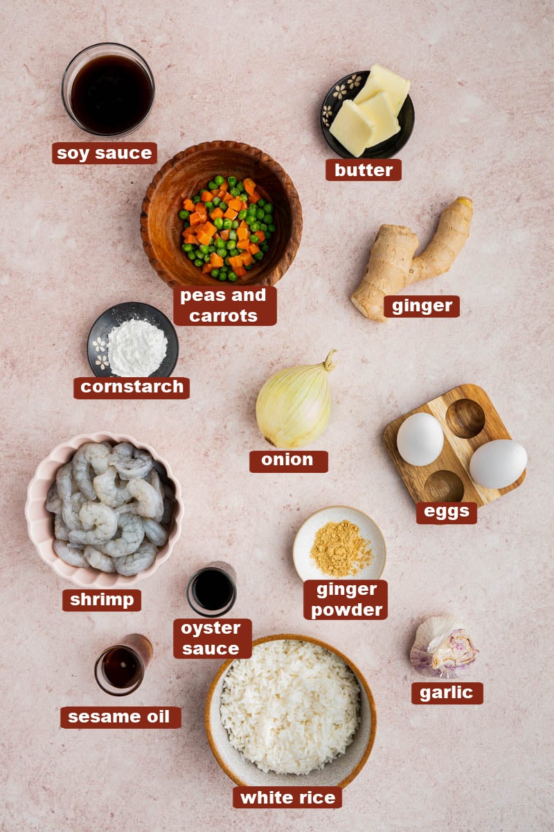 All of the ingredients for shrimp fried rice in bowls on a countertop.