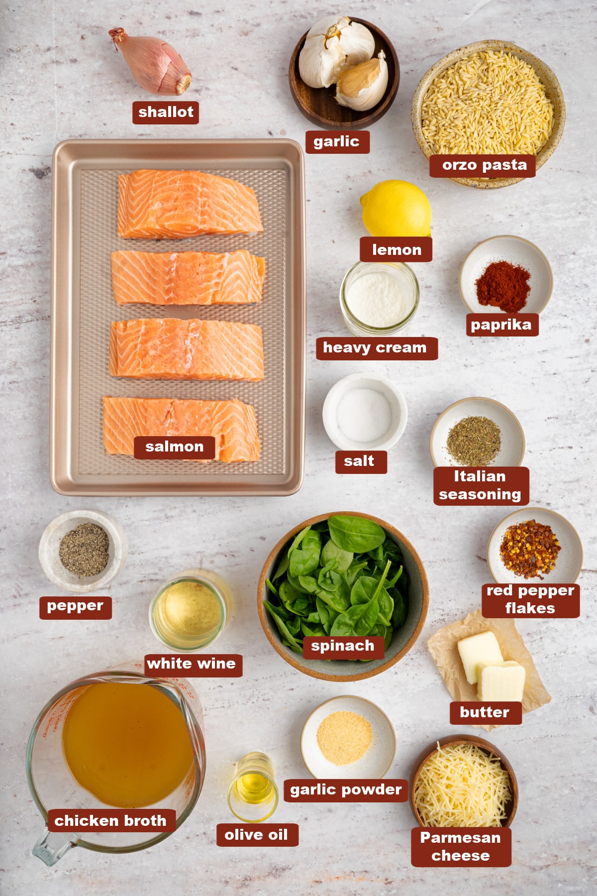 All of the ingredients for lemon salmon orzo in bowls on a white countertop.