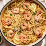 Shrimp scampi in a white skillet with linguine for serving.