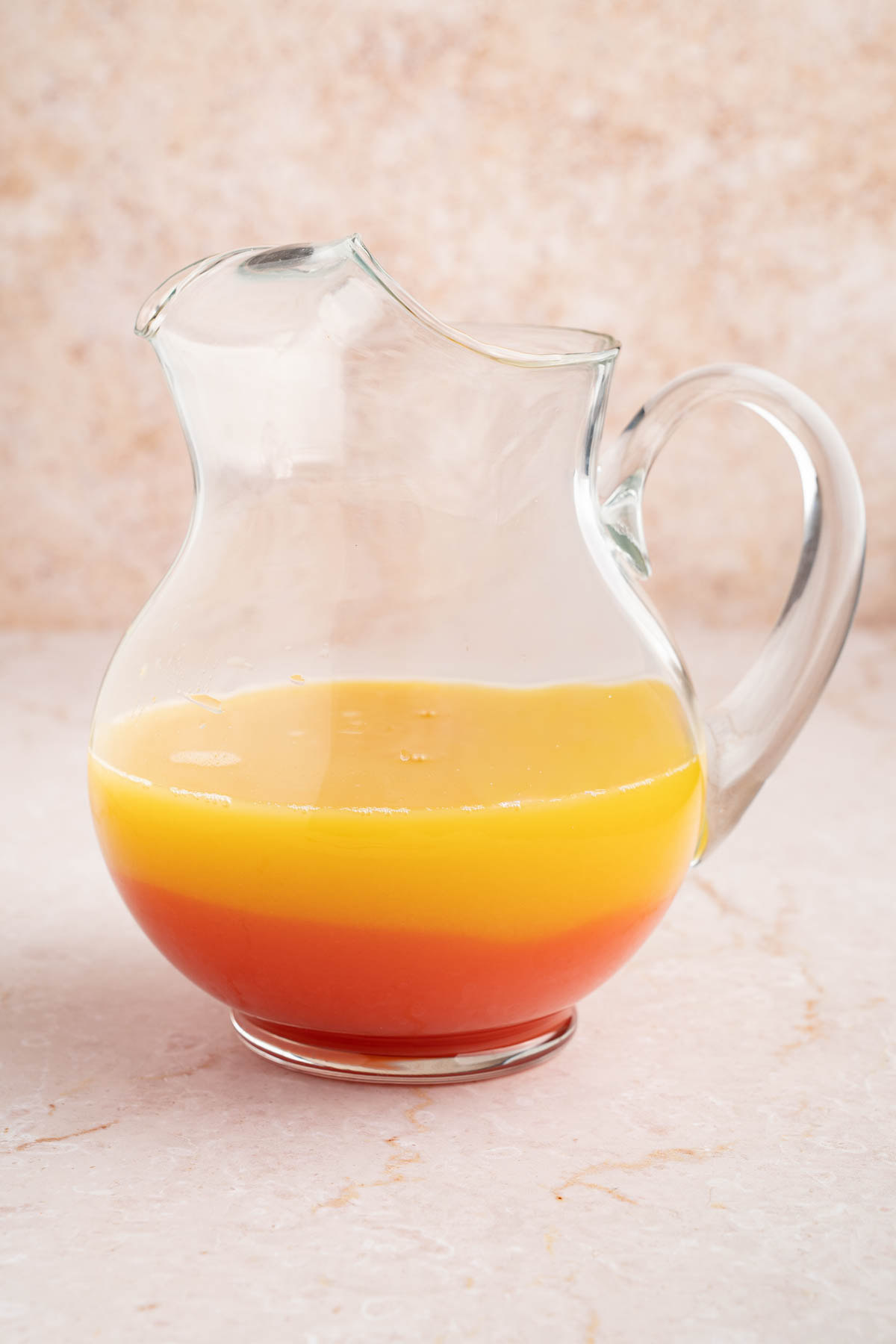 All of the ingredients for the rum punch in a pitcher before stirring.