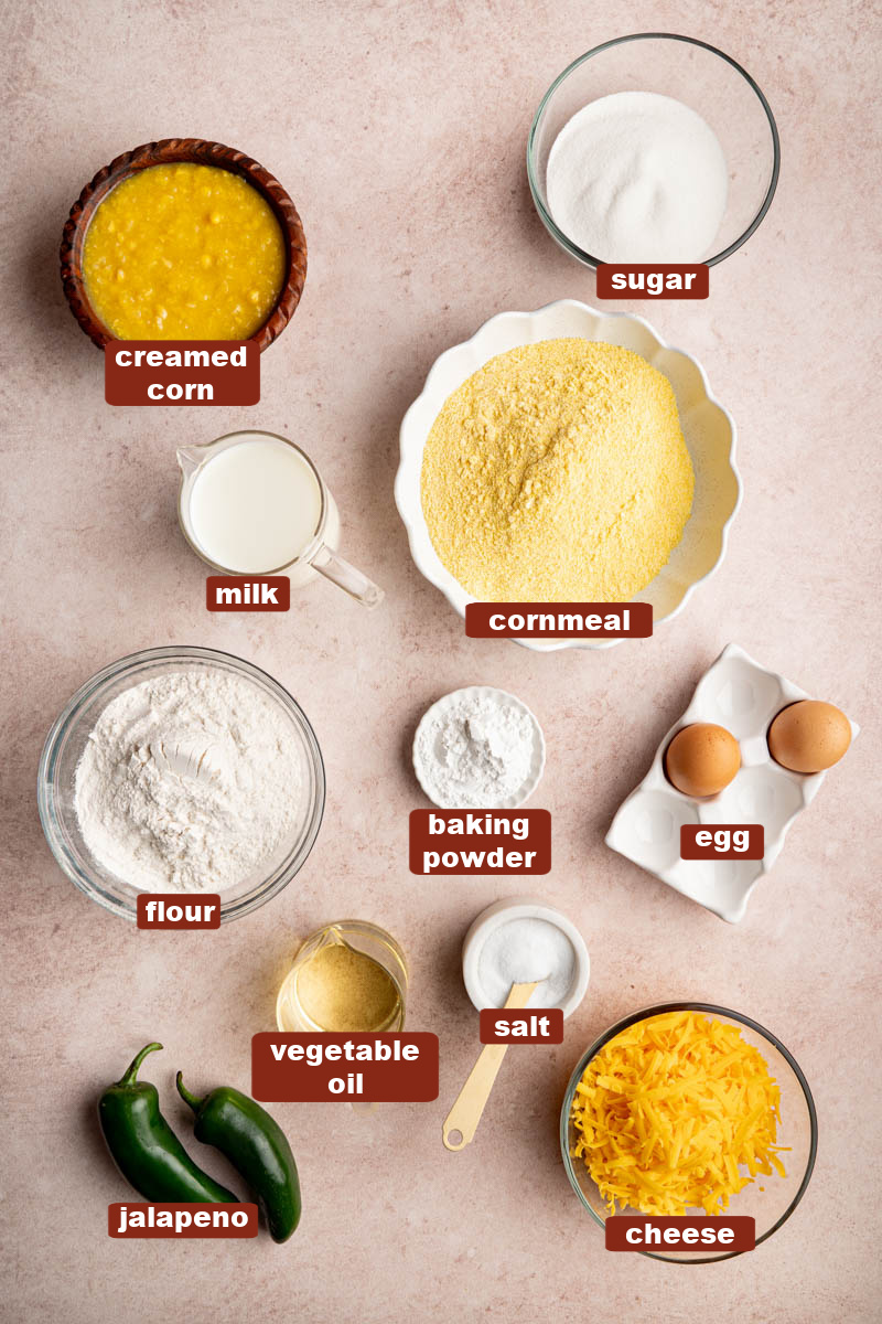 All of the ingredients for jalapeno cheddar cornbread in bowls on a countertop.