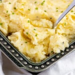 Creamy garlic mashed potatoes in a green serving dish for serving.