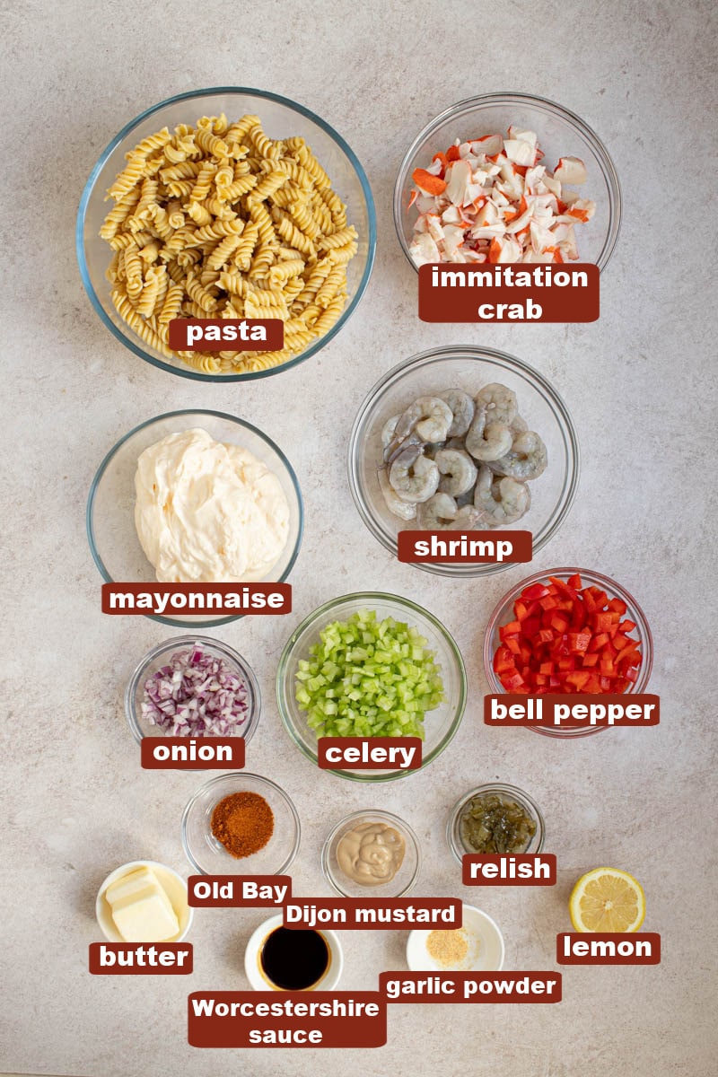 All of the ingredients for seafood salad in bowls on countertop.
