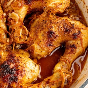 Roasted chicken leg quarters in a large dutch oven ready to be served.