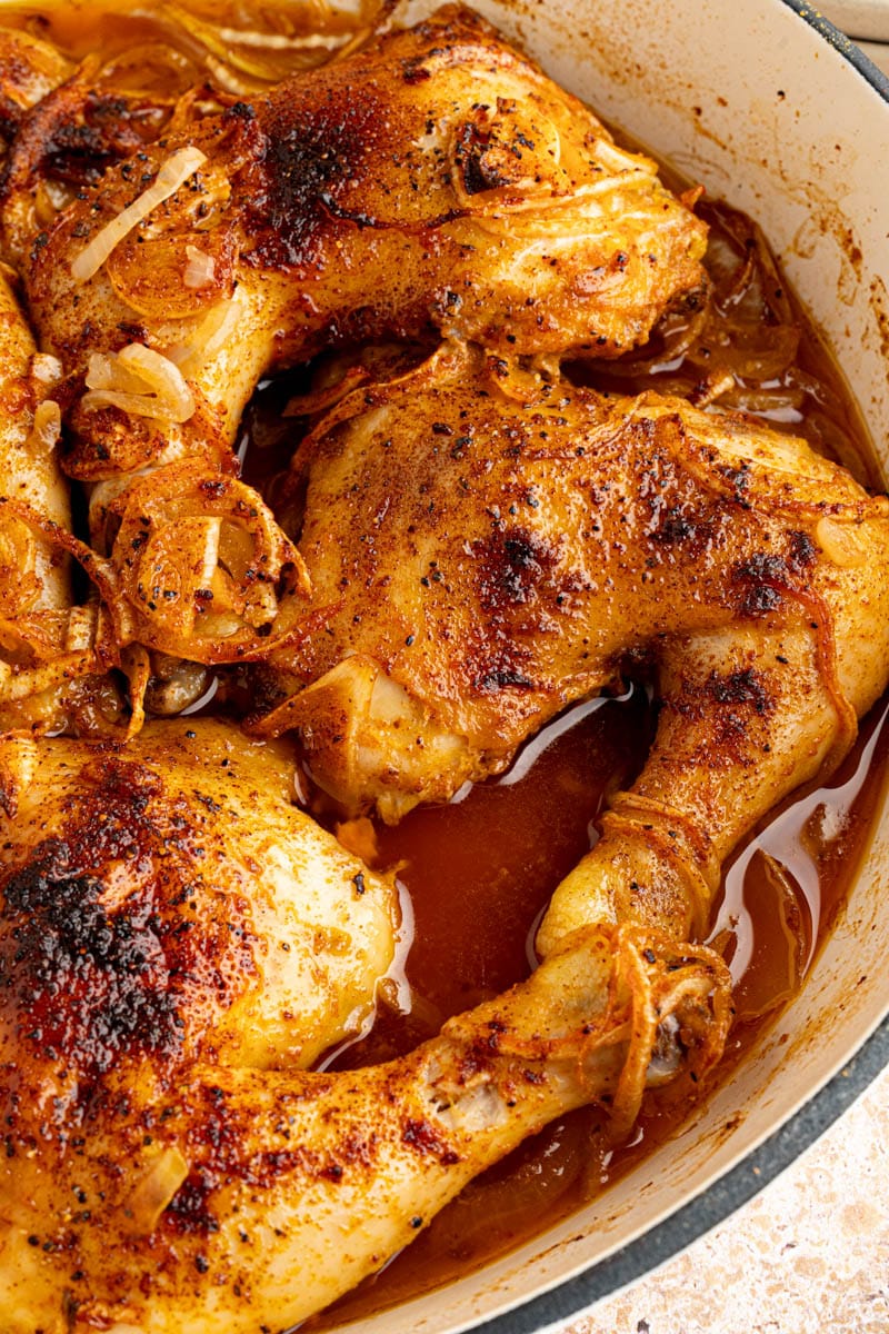 Roasted chicken leg quarters in a large dutch oven ready to be served.