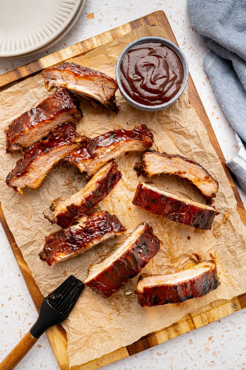 Sliced baked ribs on a wooden cutting board just before serving. 