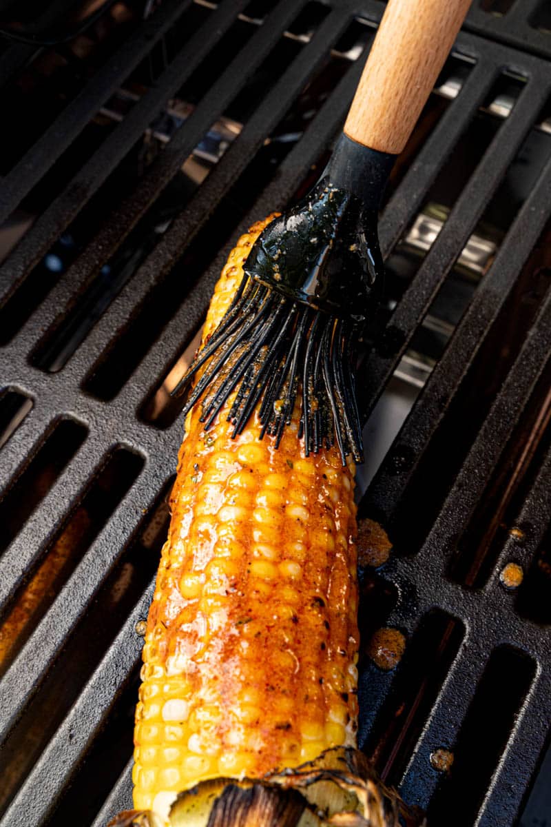 Basting the corn with the cajun butter on the grill