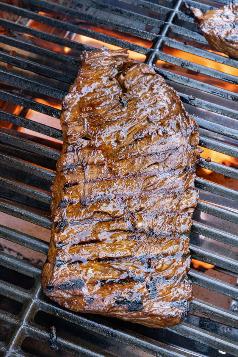 grilled skirt steak on a grill grate while grilling