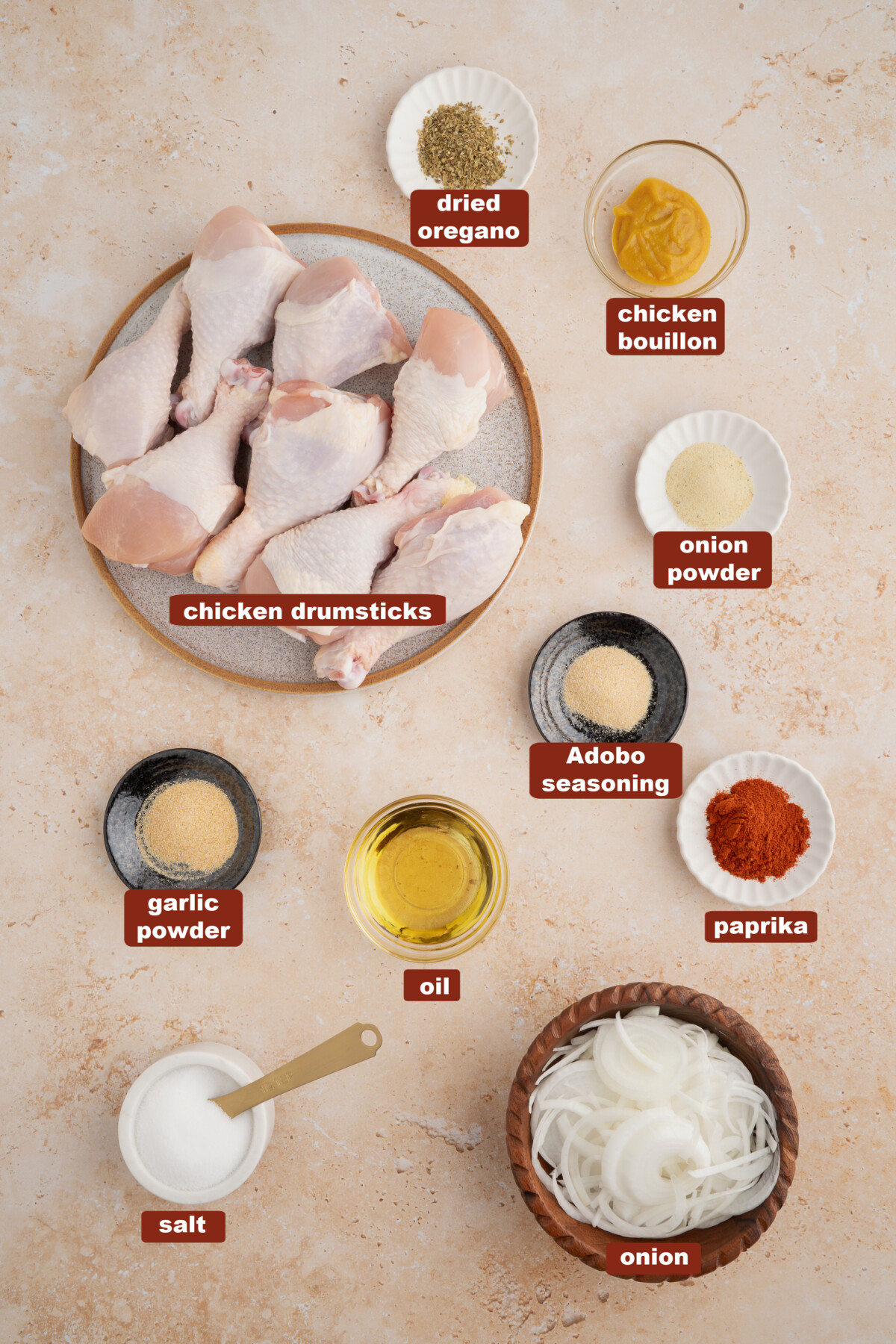 All of the ingredients for baked chicken legs in bowls on a countertop.