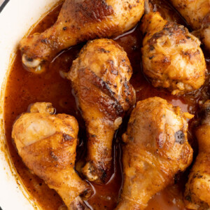 Baked chicken drumsticks in a pan before serving.