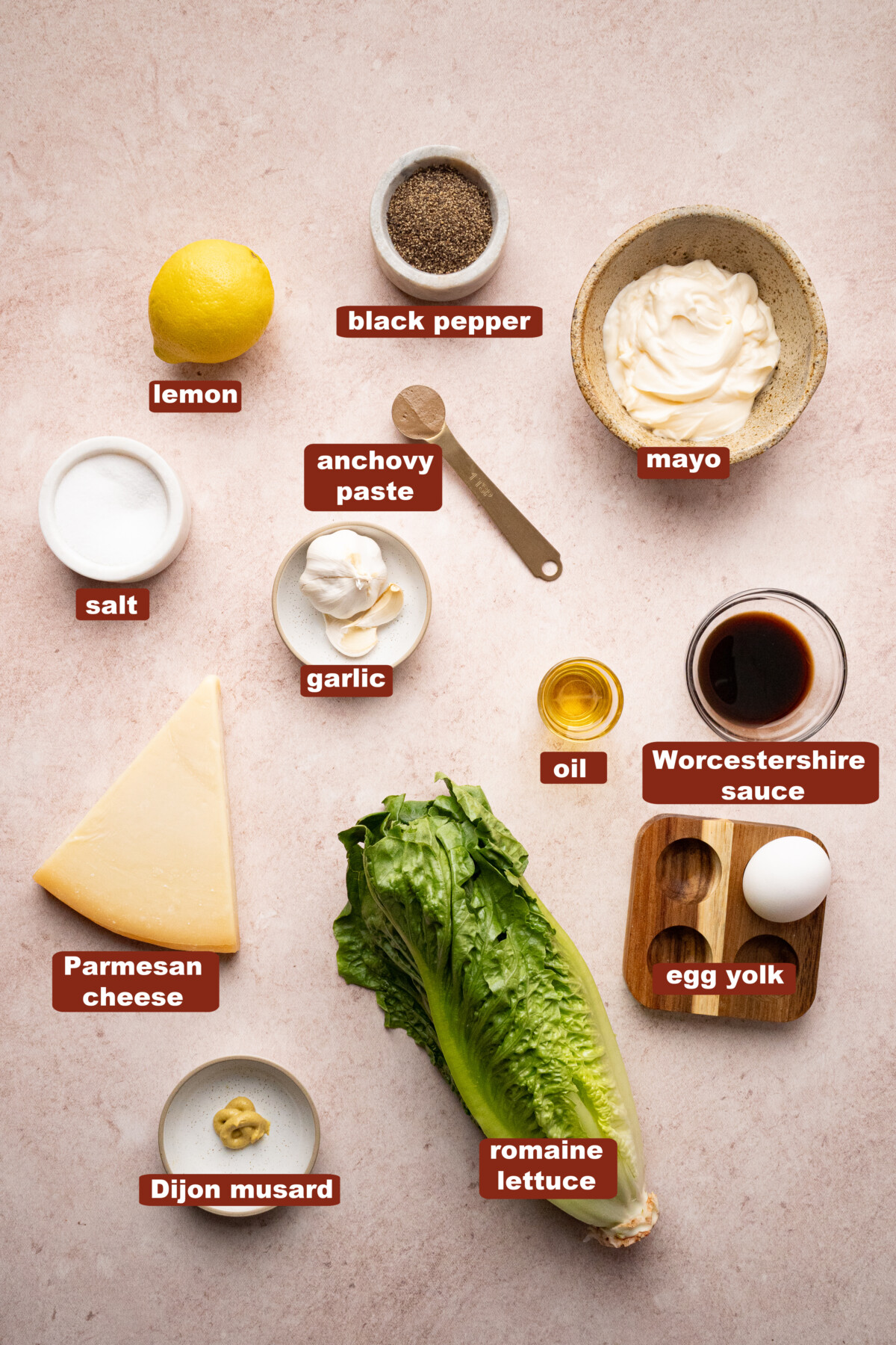 All of the ingredients for caesar salad in bowls on a countertop.