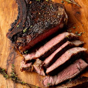 Ribeye steak on a cutting board sliced before serving.