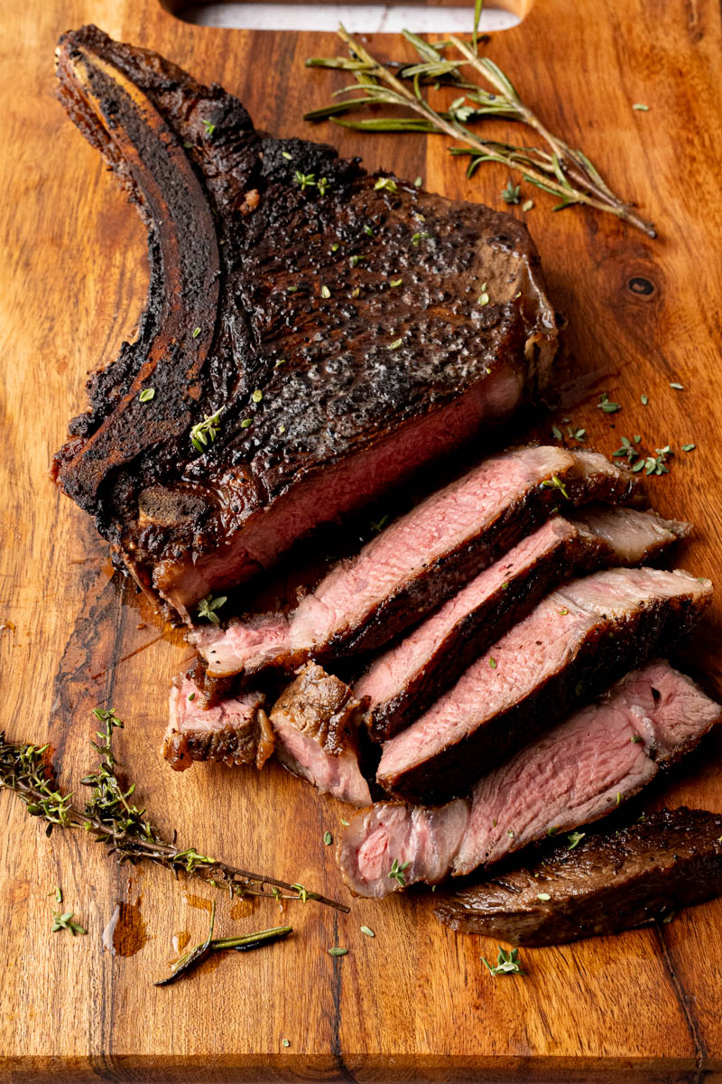 Ribeye steak on a cutting board sliced before serving.