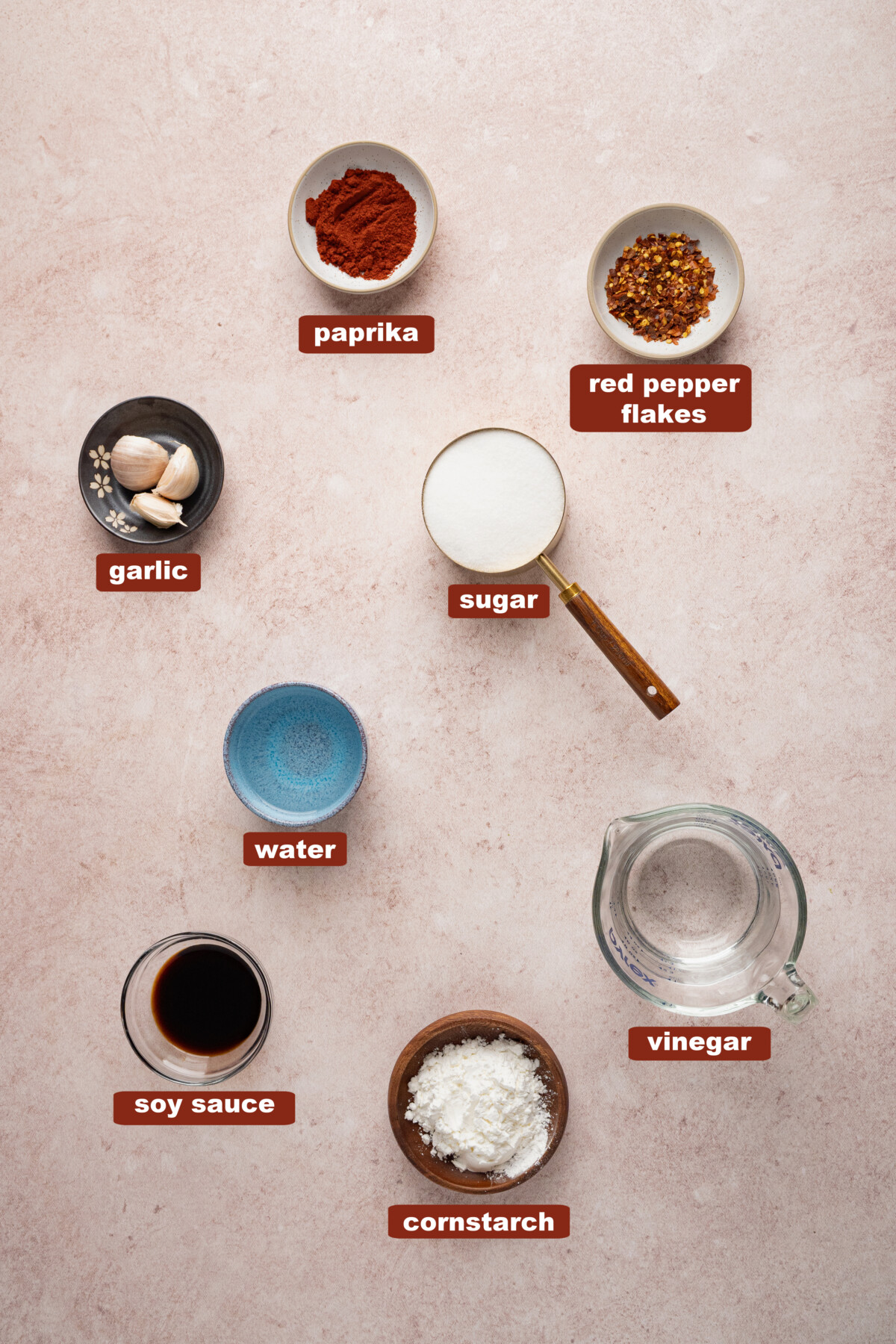 All of the ingredients for sweet chili sauce in bowls on a countertop.