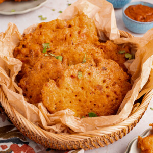 A basket filled with bacalaitos (or codfish fritters) sits on a countertop with napkins.