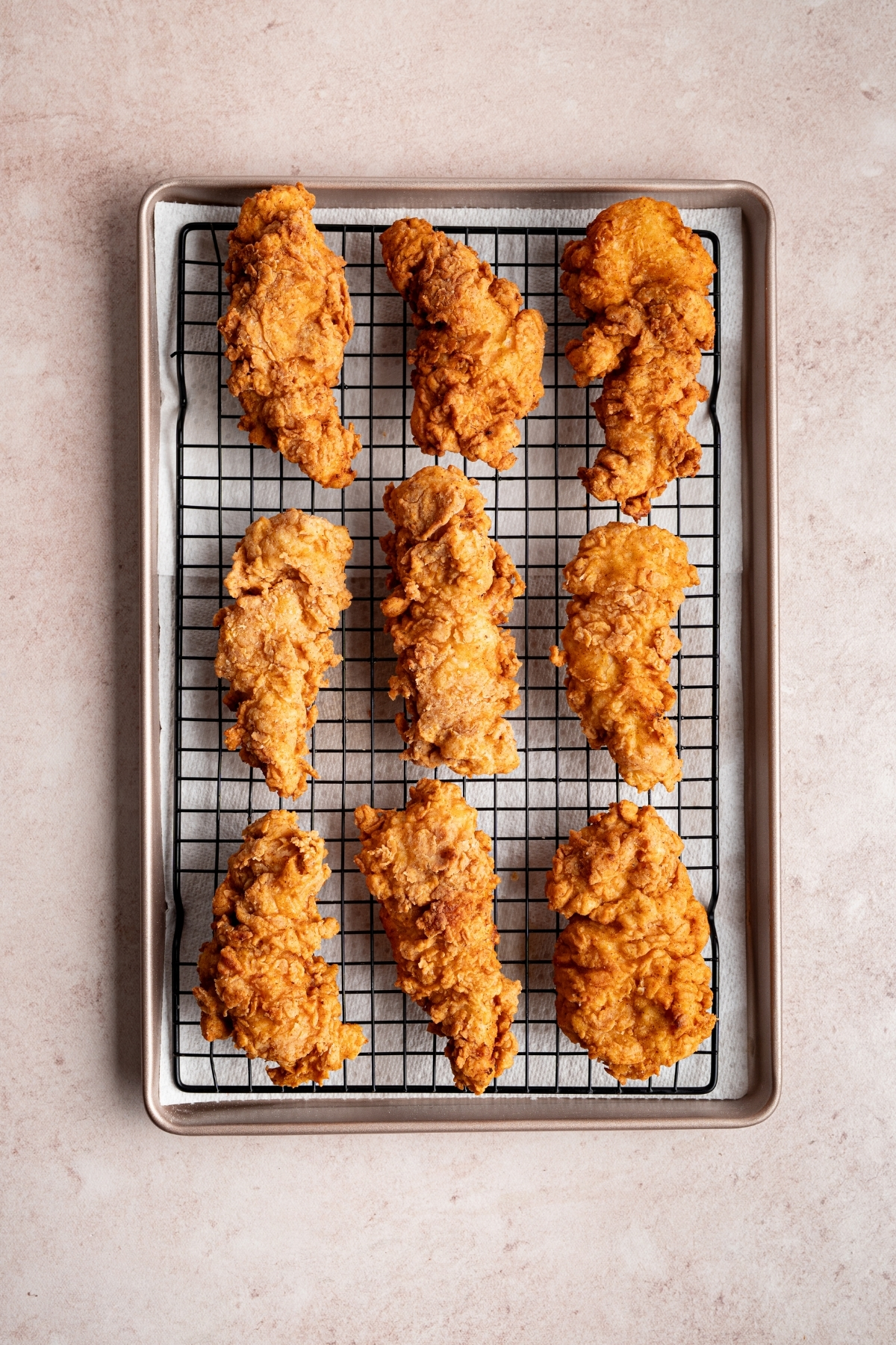chicken strips seen lined on a baking tray fried and golden