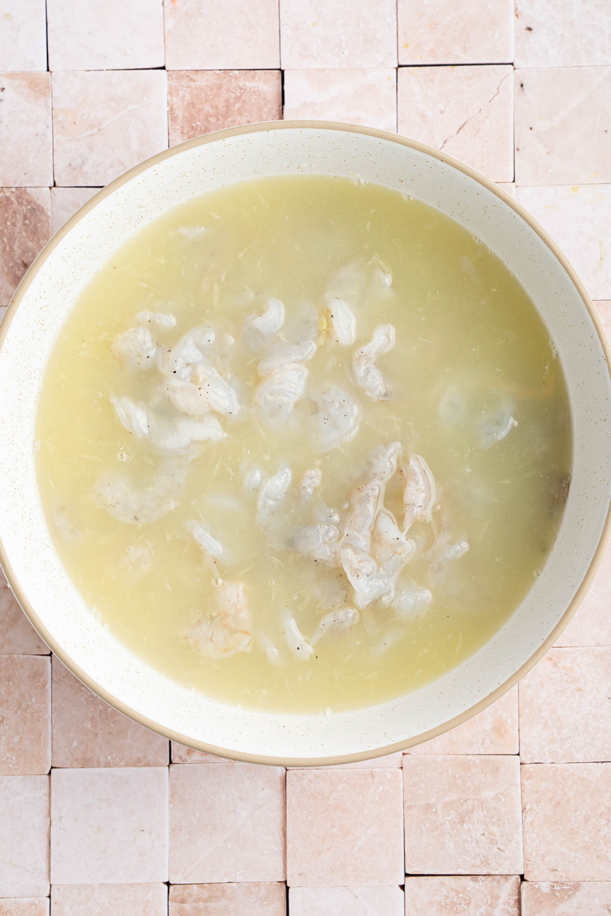The shrimp in a bowl covered in lime juice.