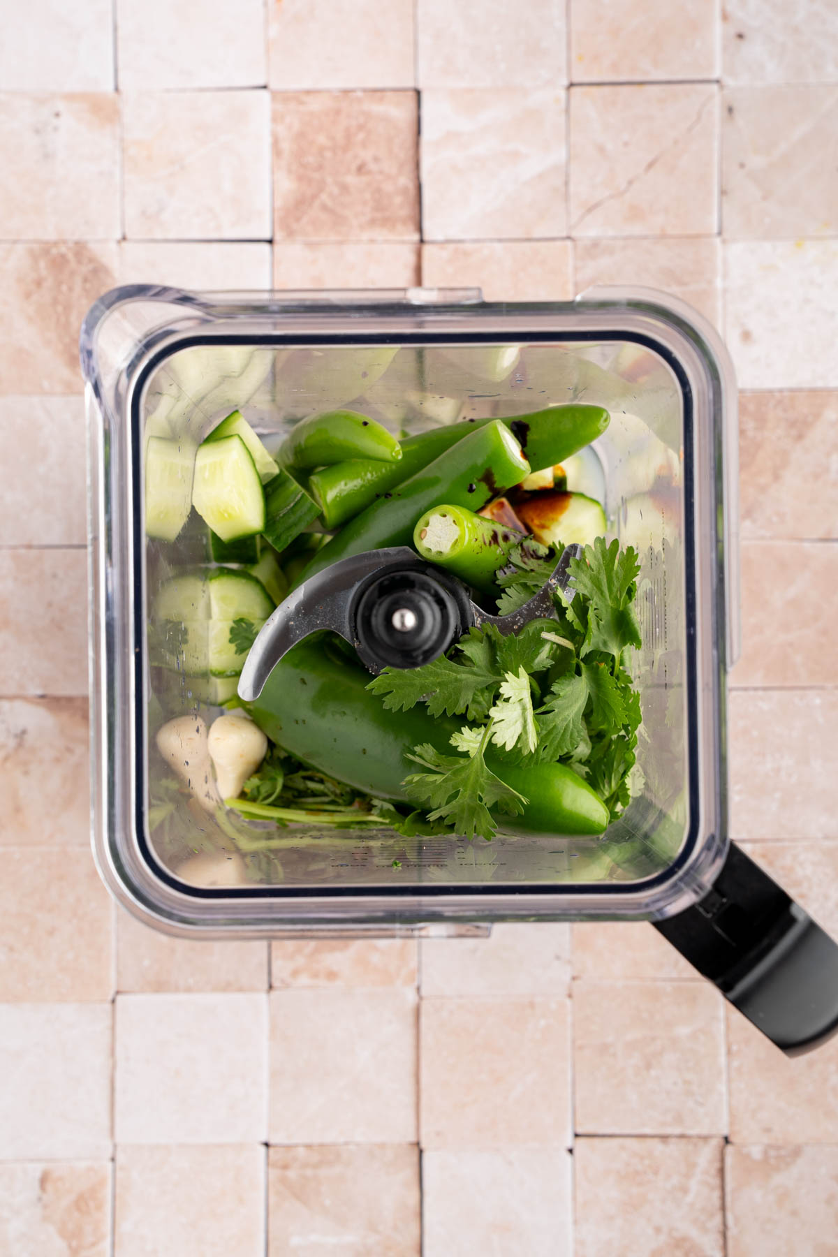 The cucumber, peppers, cilantro, garlic, juggo maggi, worcestershire sauce and lime juice in a blender before blending.