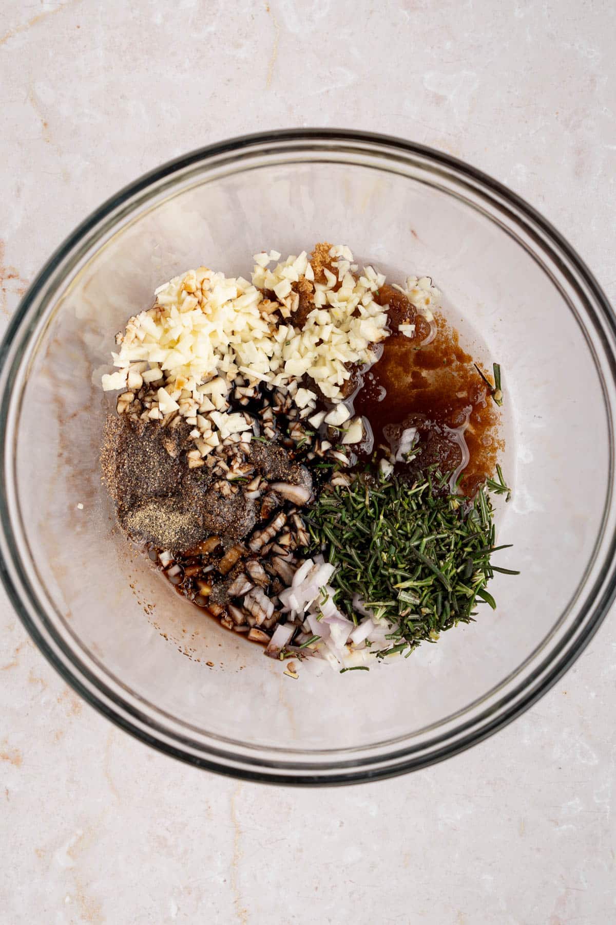 All of the marinade ingredients in a glass bowl on a countertop.