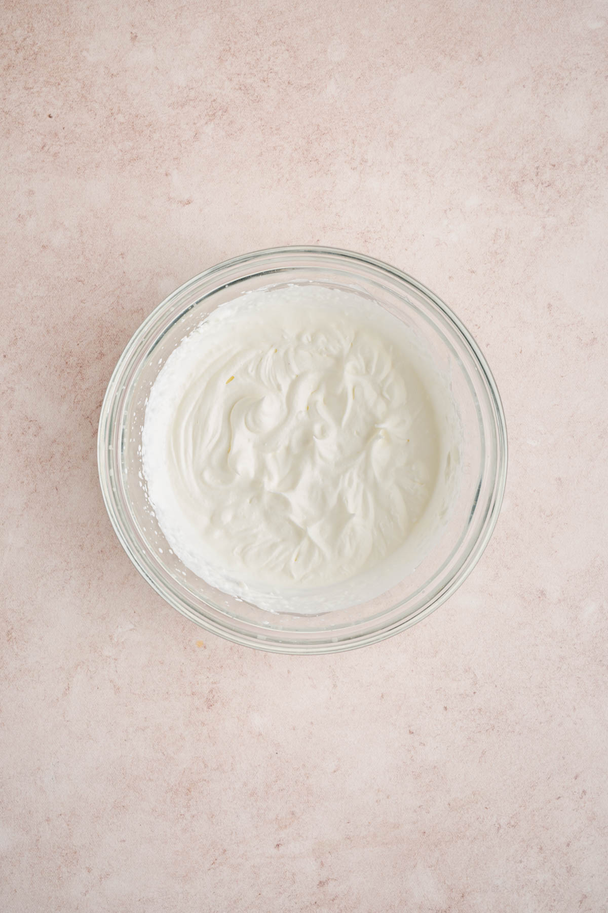 The whipped cream in the bowl after beating until stiff peaks form.