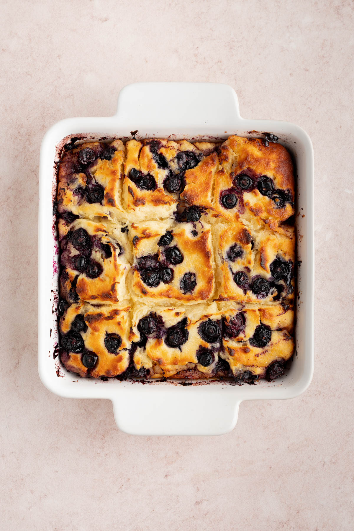 The baked biscuits in a square baking dish on a countertop.