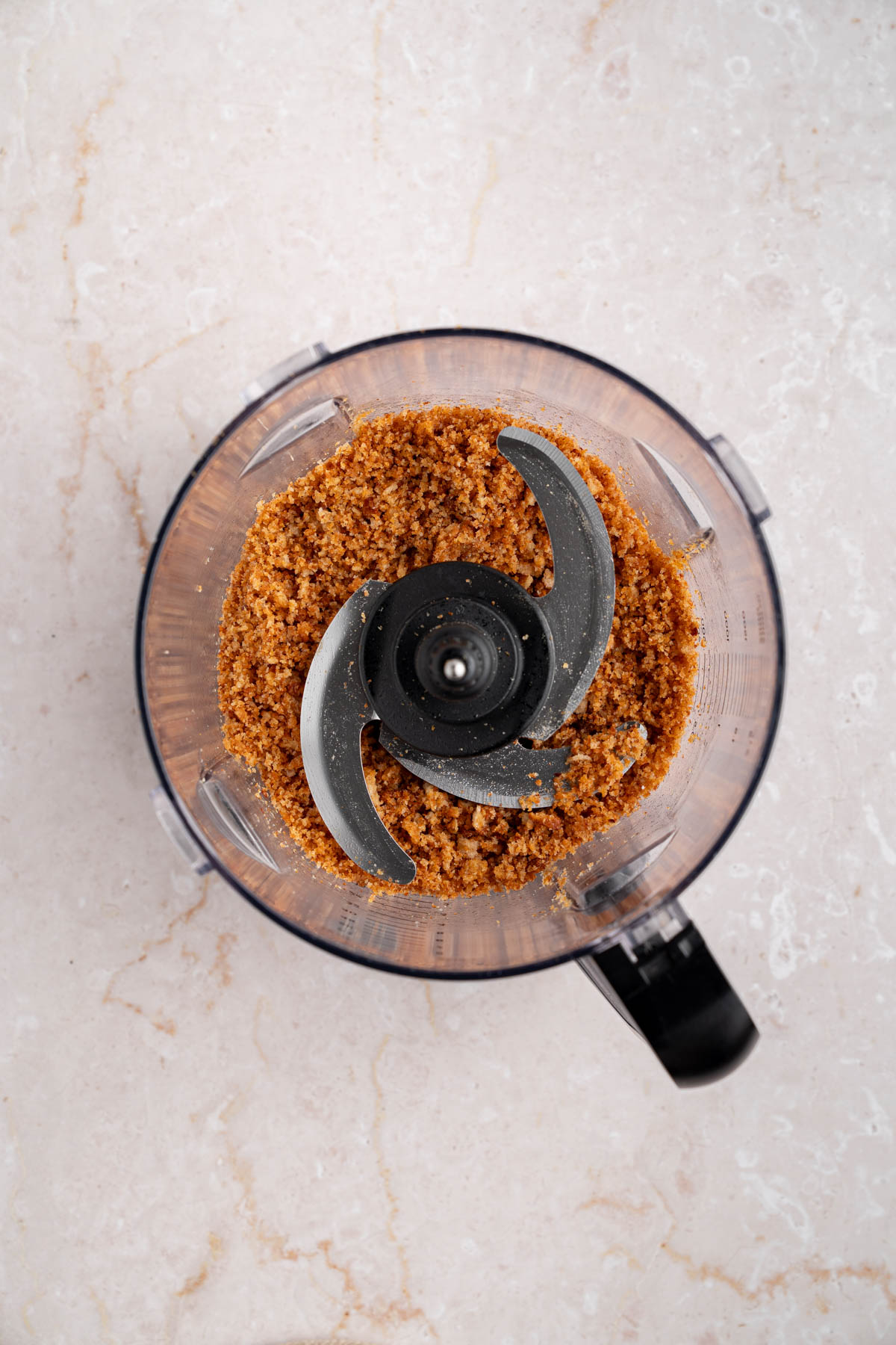 The breadcrumbs in a food processor bowl.