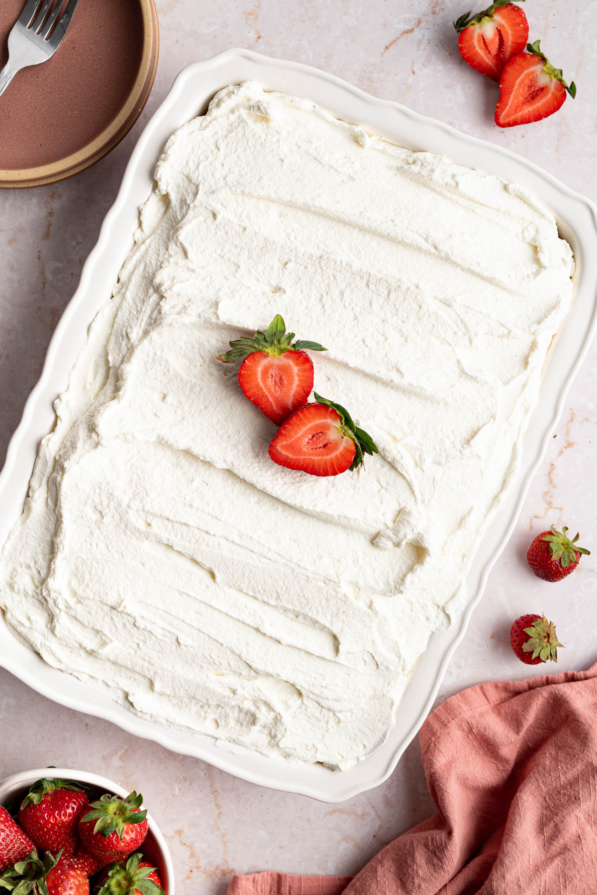 The cake decorated with the frosting and slices of strawberries.