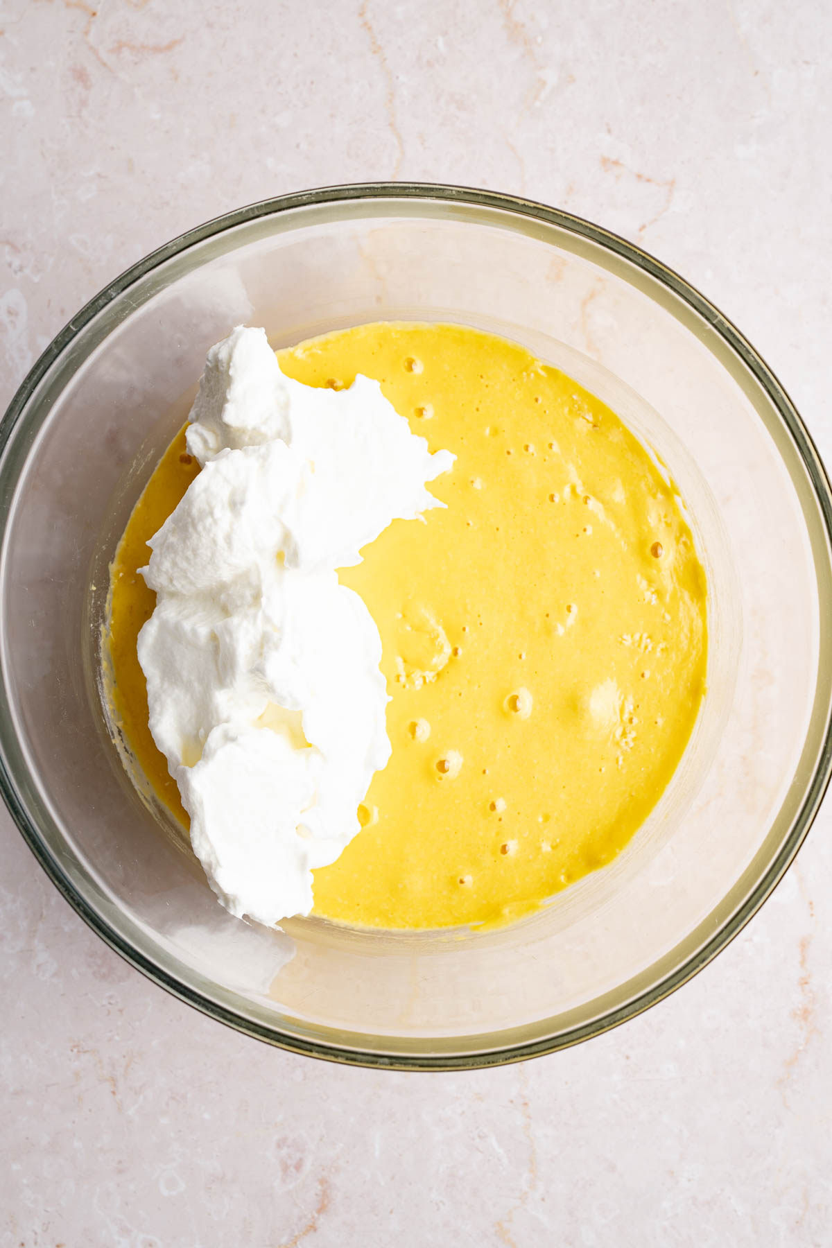 The beaten egg white mixture in the bowl with the cake mixture before stirring everything together.
