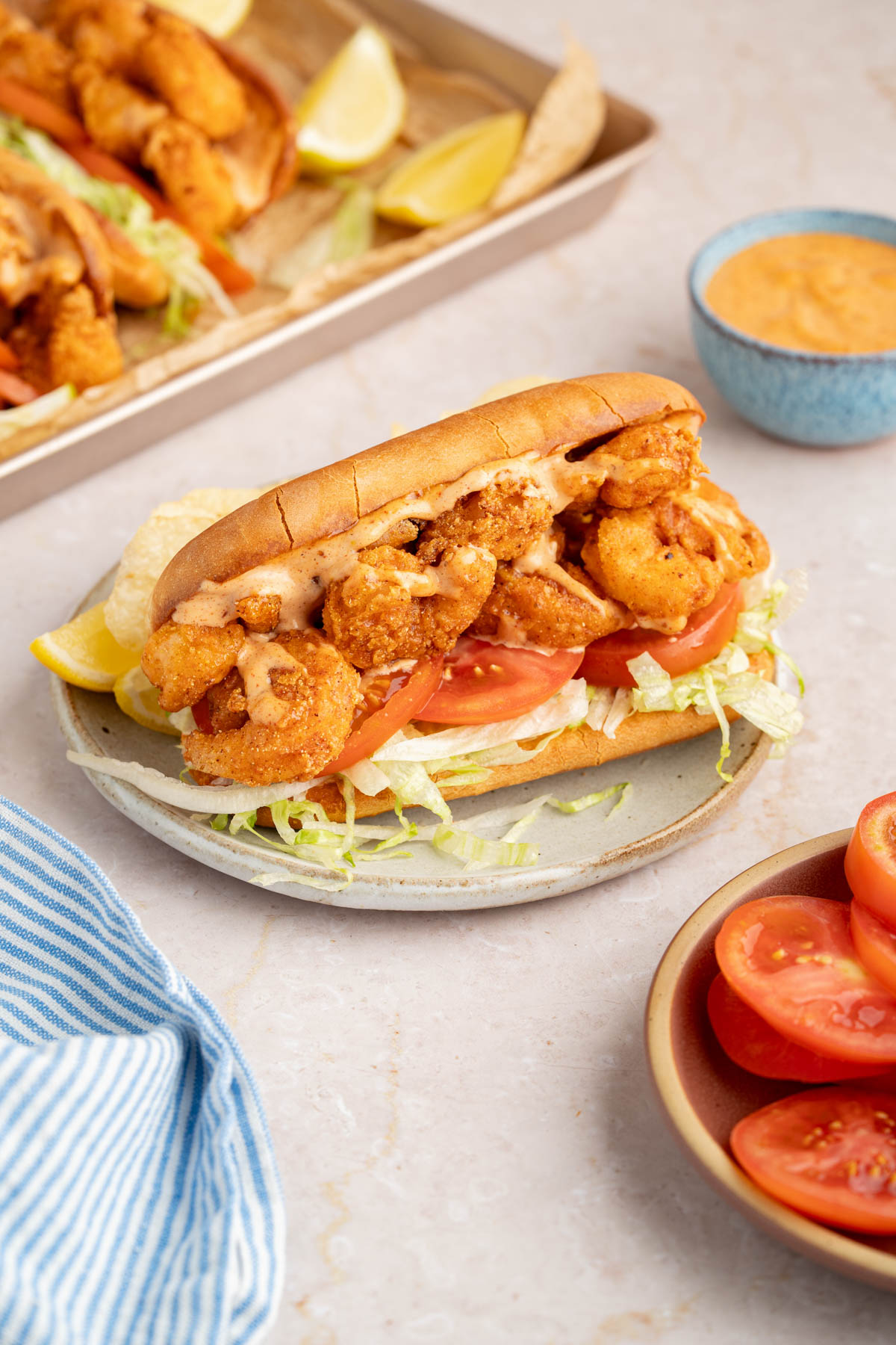 The final shrimp po' boy assembled on a plate for serving.