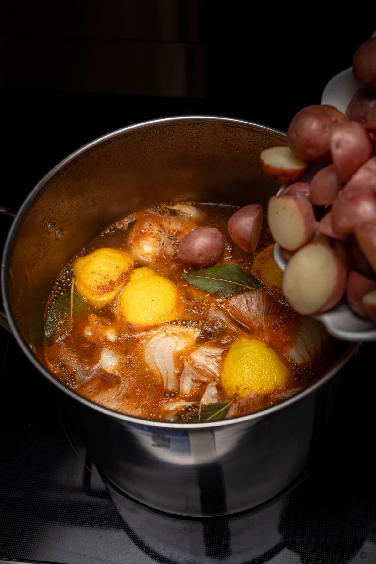 The potatoes in the pot with the other boil ingredients.