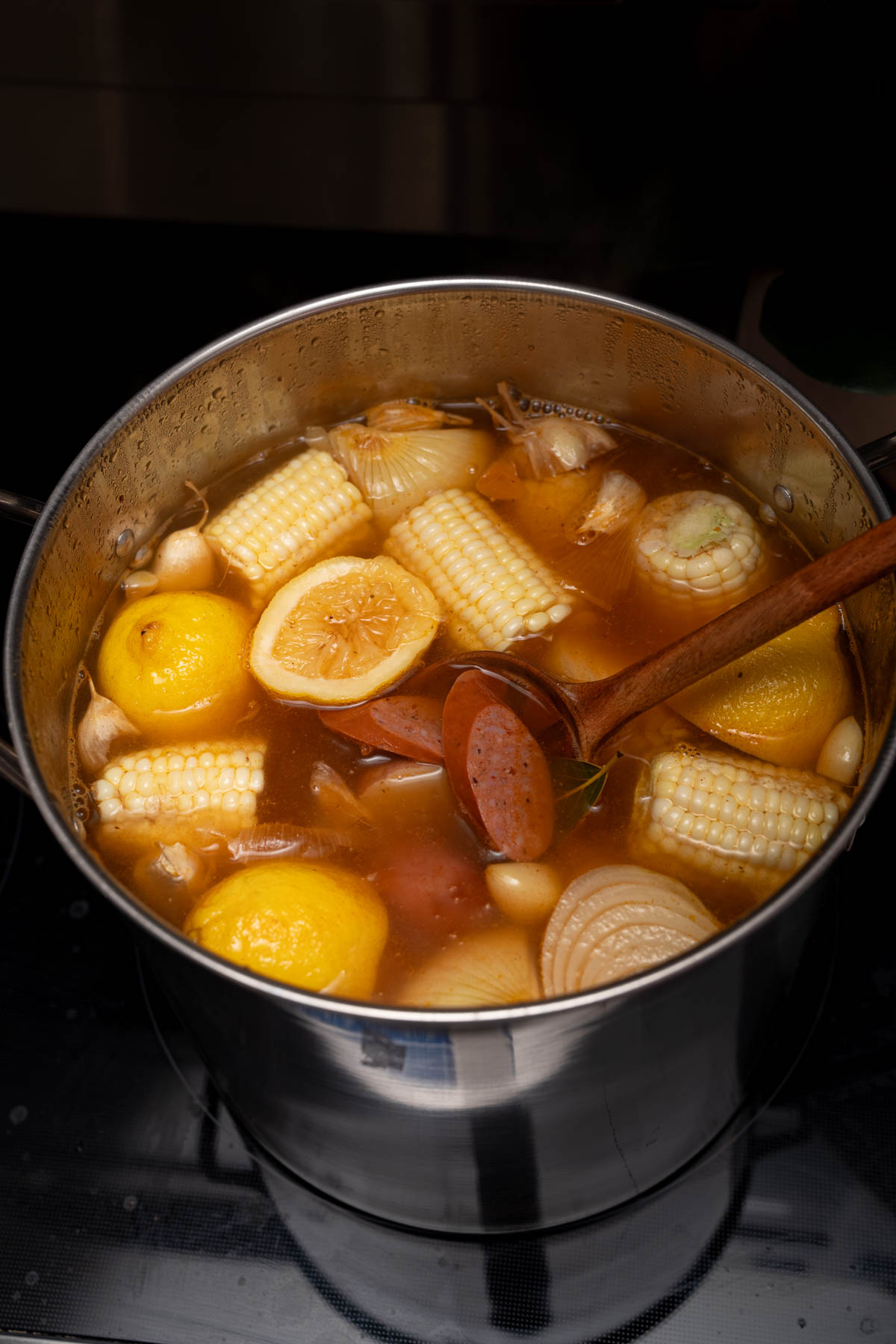 The corn and sausage in the stock pot with the other ingredients.