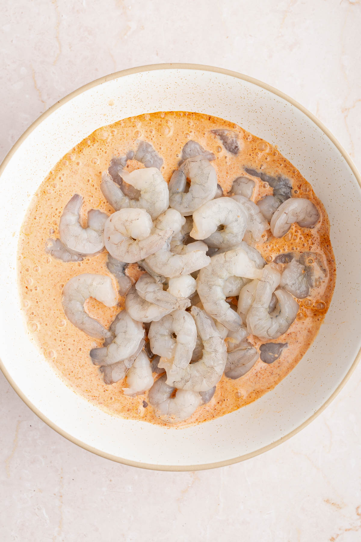 The shrimp in a large white bowl with the buttermilk sauce.