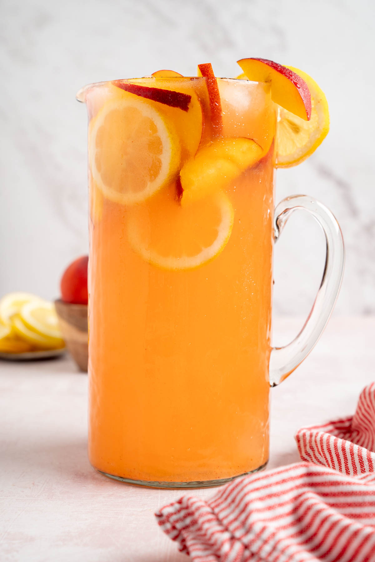 A pitcher filled with peach lemonade.