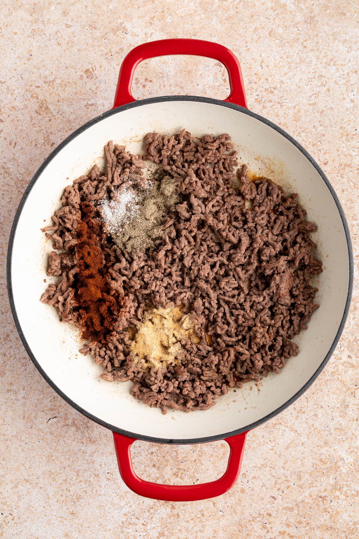 The seasonings on the cooked ground beef before stiring.