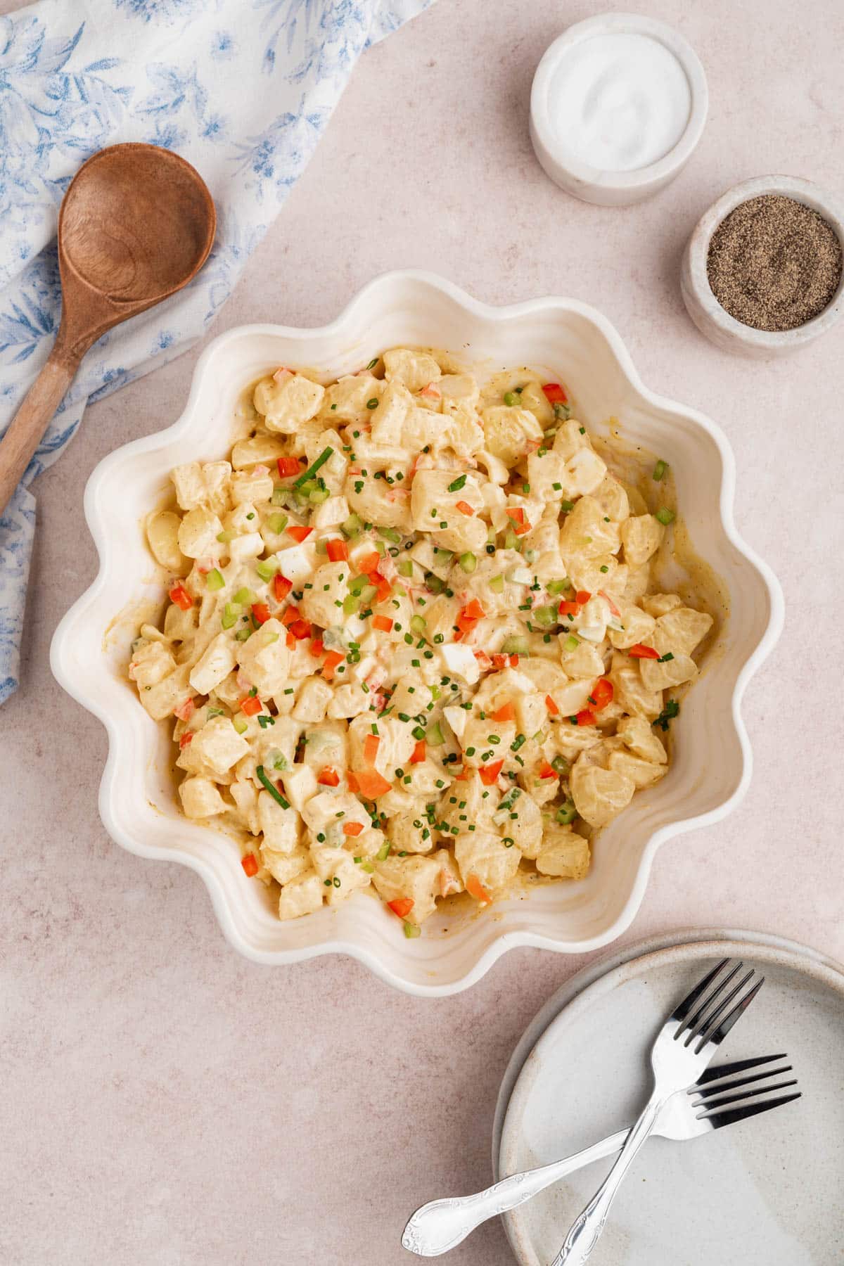 The ensalada de papa in a white serving bowl on a countertop.
