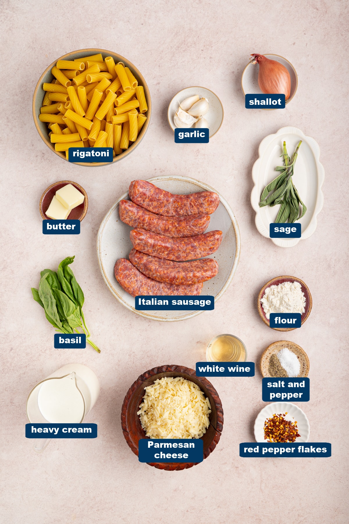 All of the ingredients for sausage rigatoni skillet in bowls on a countertop.