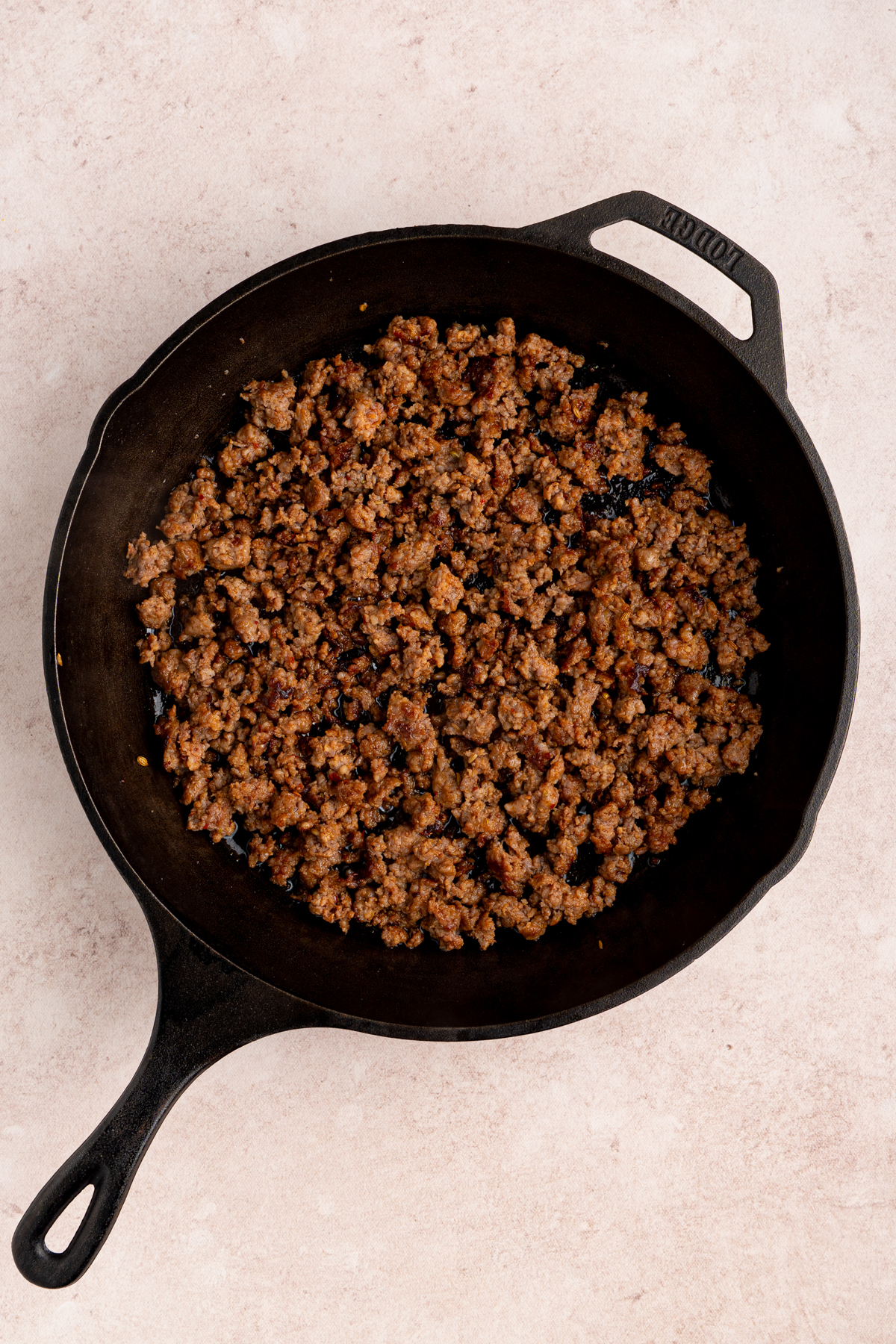 The sausage cooked in a cast iron skillet.