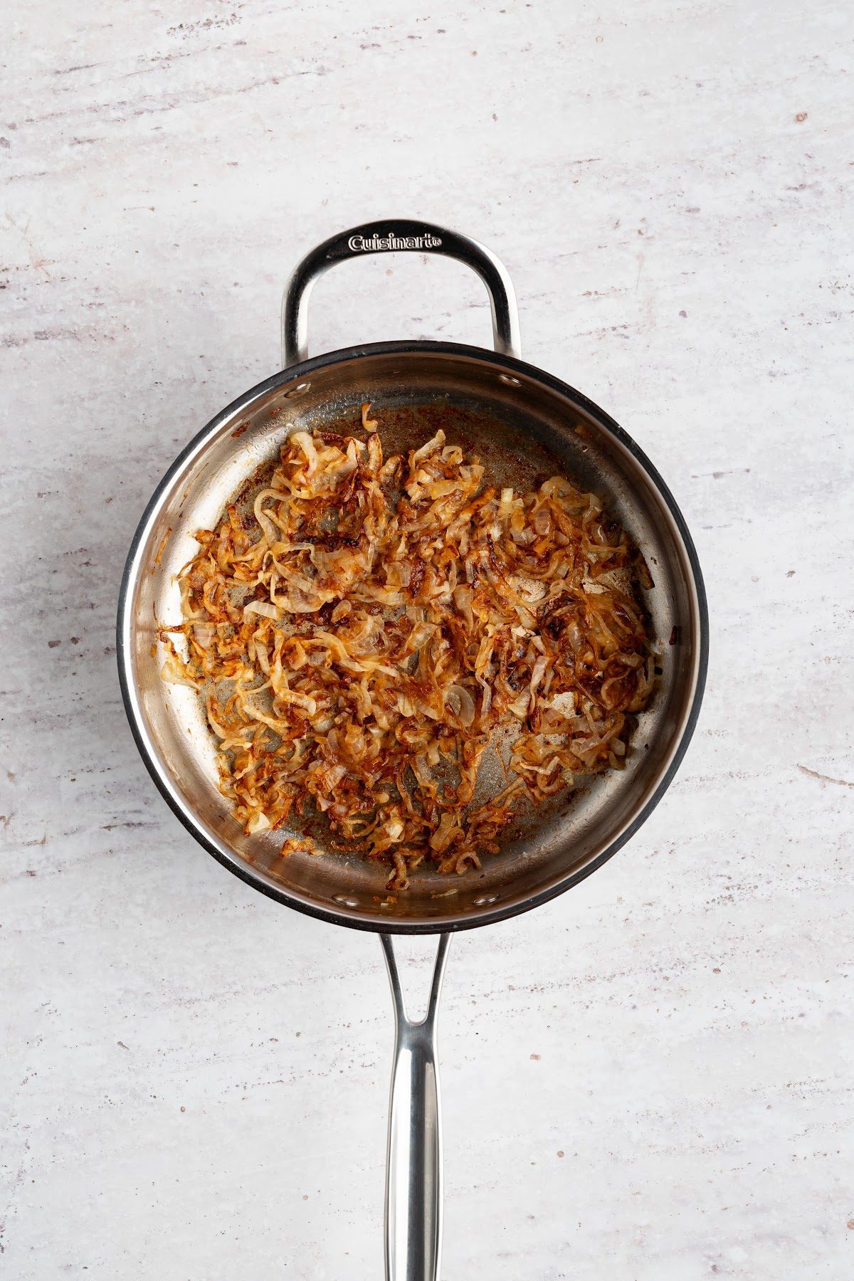 Thinly sliced yellow onions cooked down to deep golden brown and jammy in a skillet