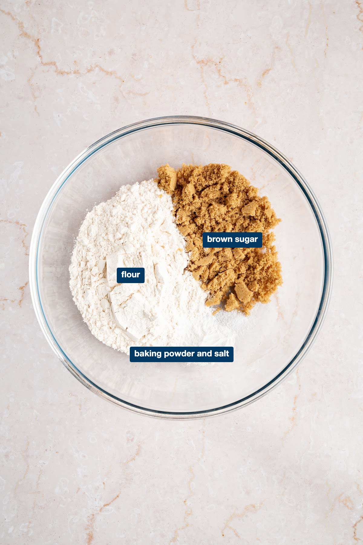 Labeled dry ingredients for the biscuit topping: all-purpose flour, dark brown sugar, baking powder and salt in a glass bowl