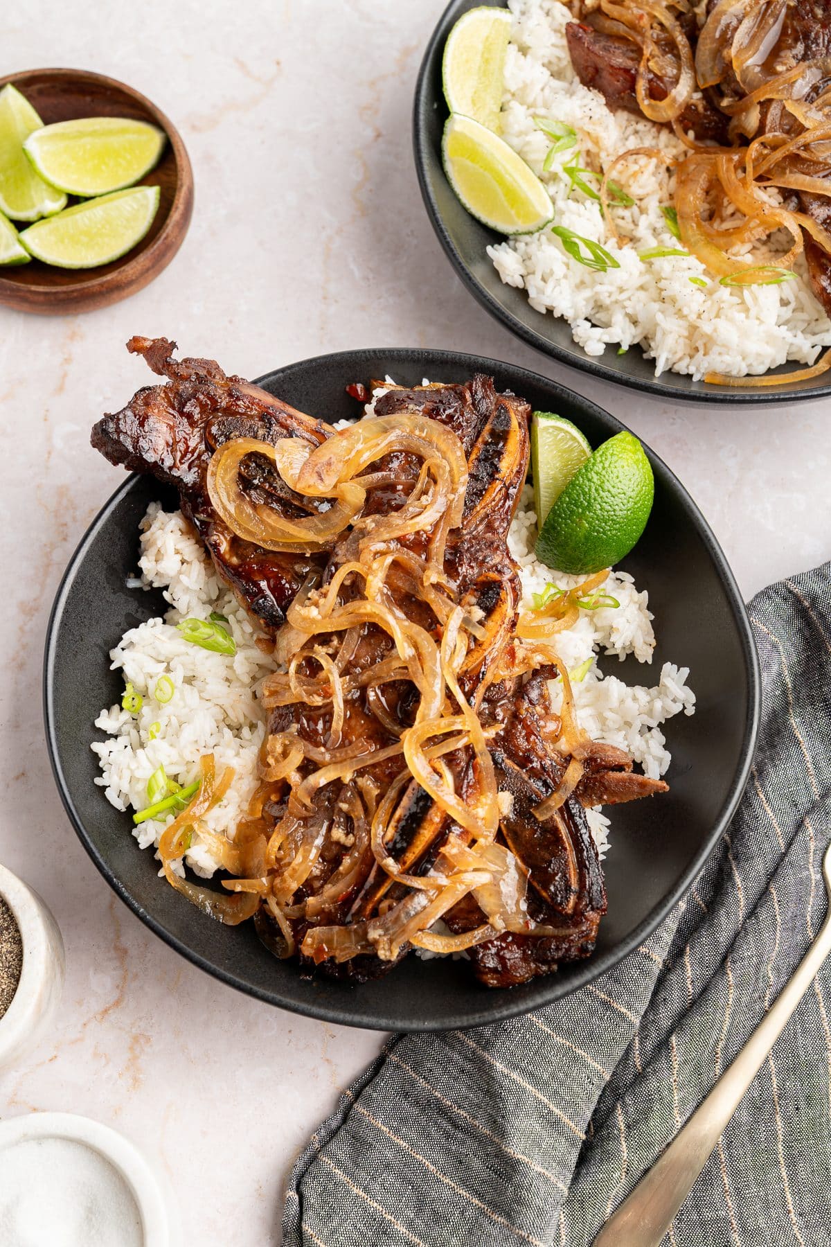 Caramelized sheet pan Korean short ribs plated over rice with jammy onions and a lime wedge
