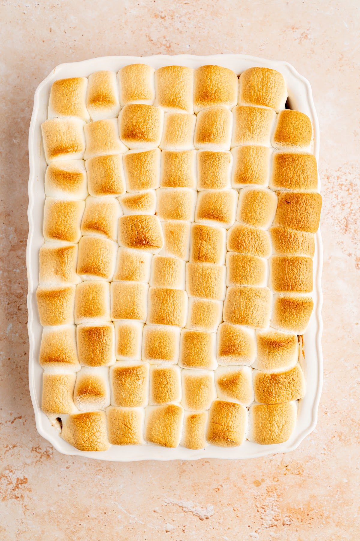 Marshmallows puffed and toasted golden brown across the top of the candied yams