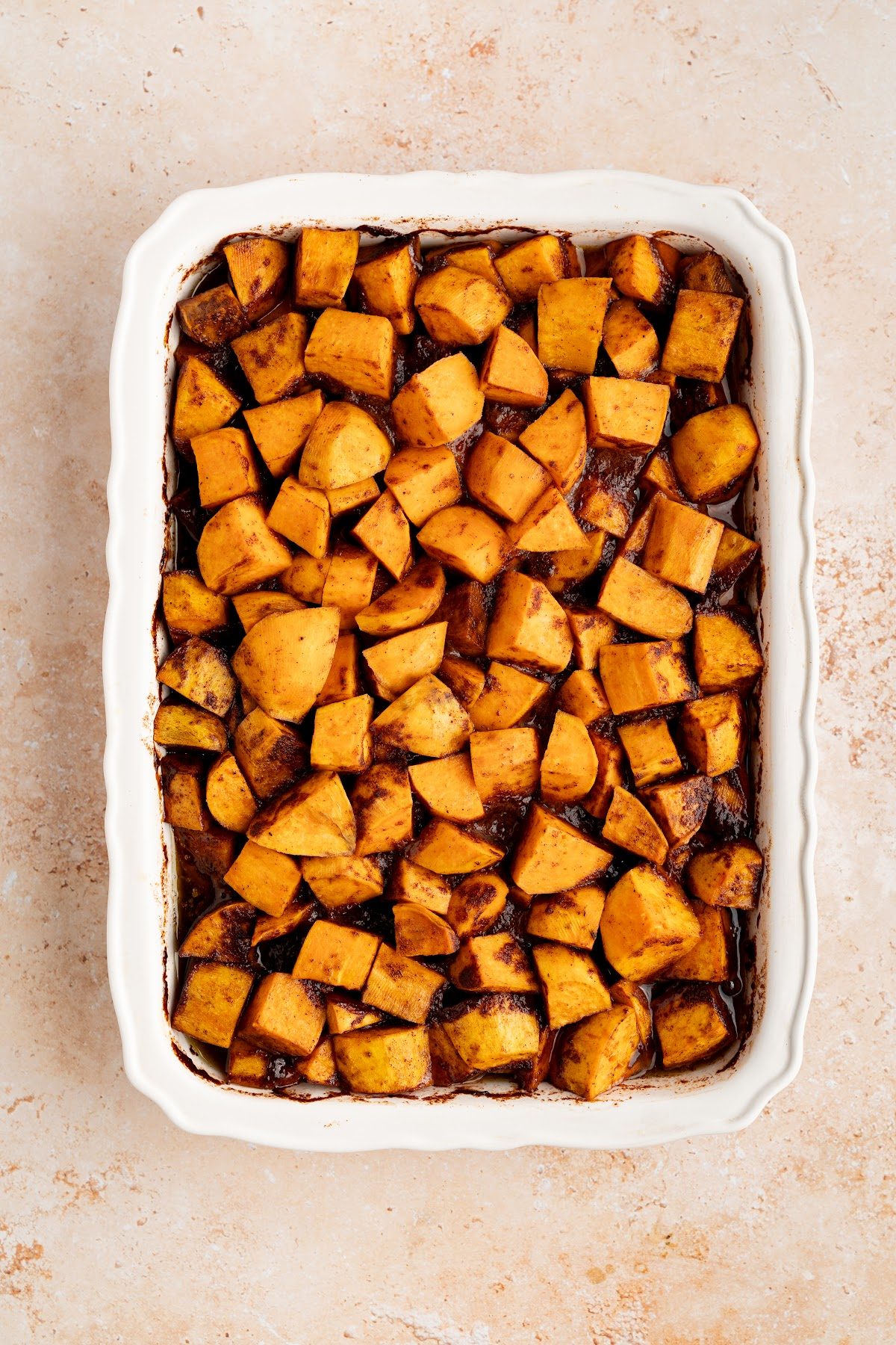 Yams tossed until every piece is coated and sitting in a thick layer of spiced syrup